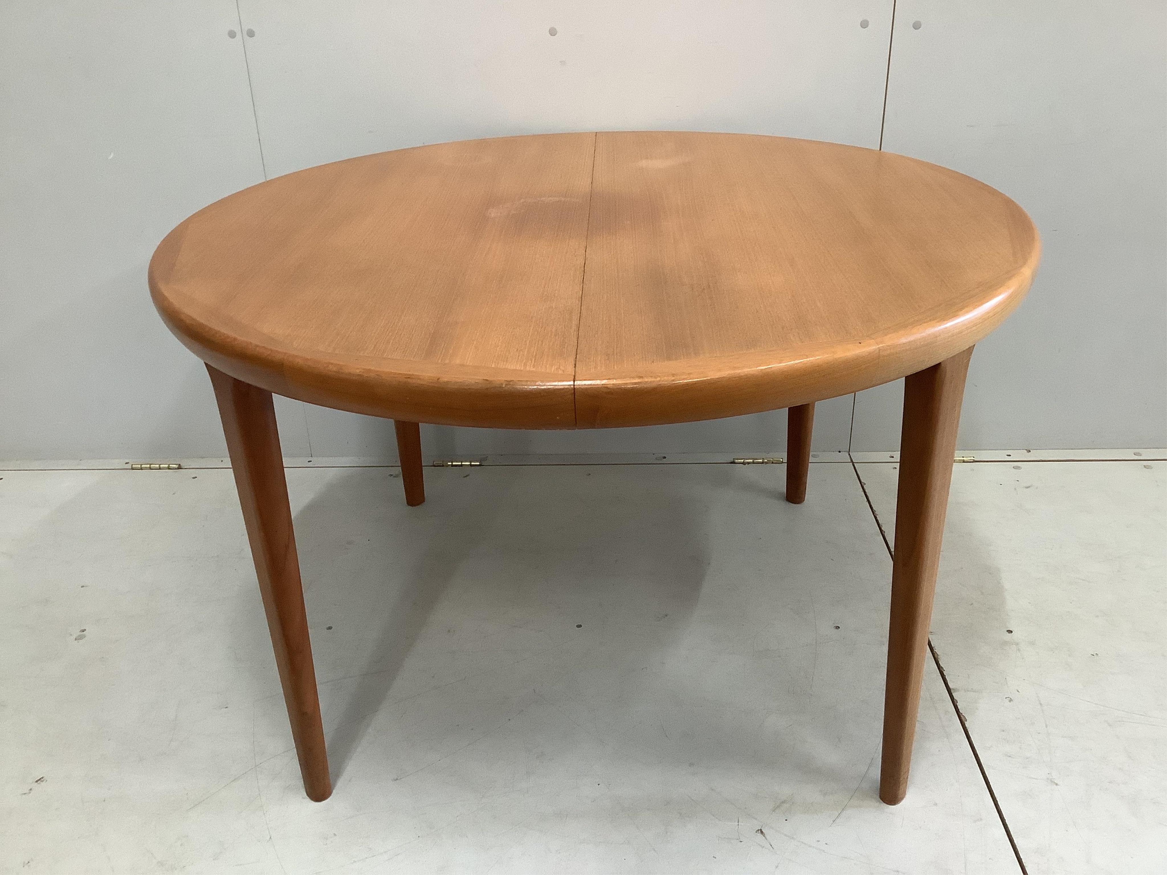 A mid century teak oval extending dining table, width 220cm extended, two spare leaves, depth 120cm, height 72cm and six chairs